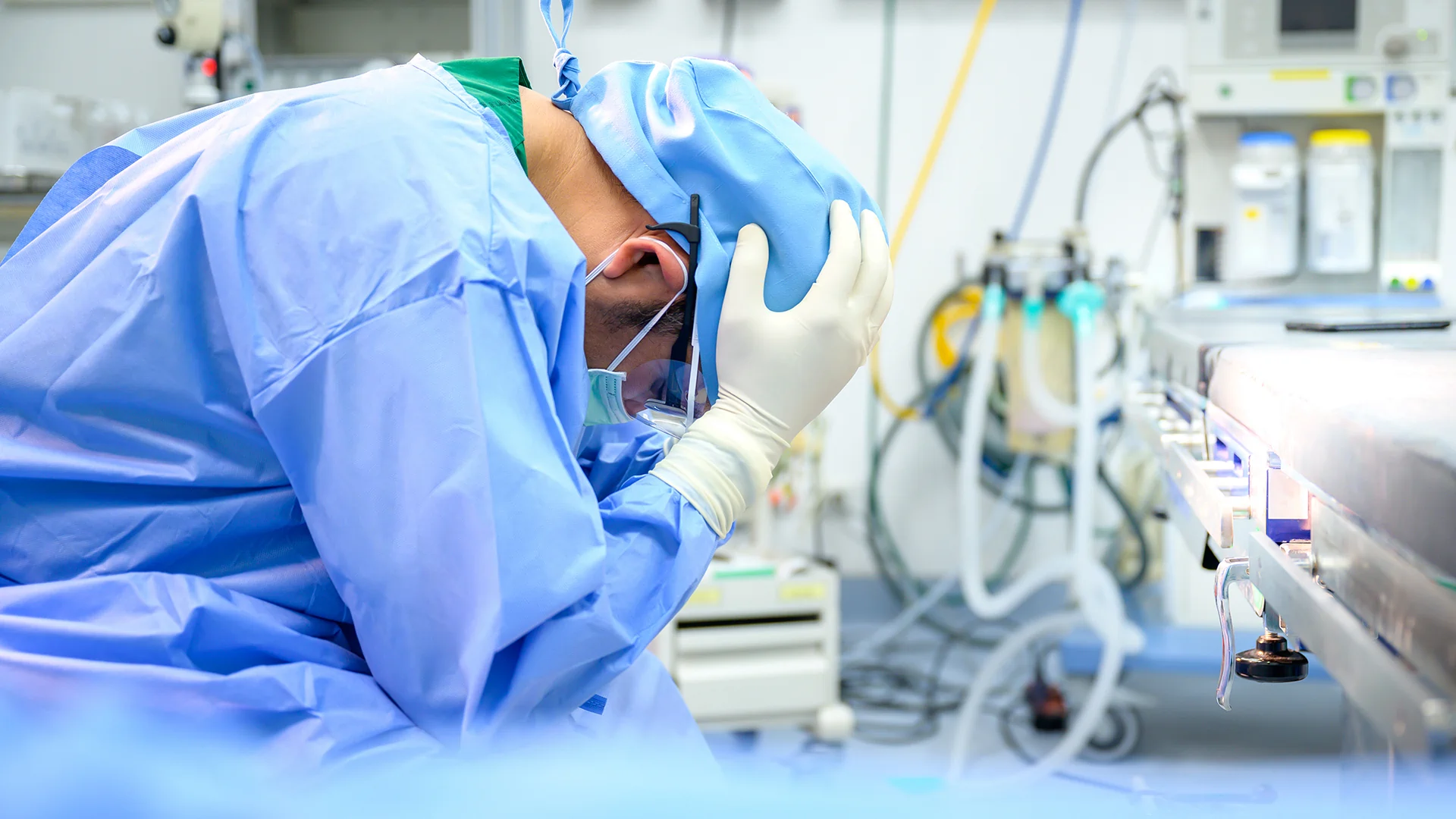 Chirurgo in sala operatoria si tiene il capo tra le mani, simbolo delle conseguenze di un errore medico